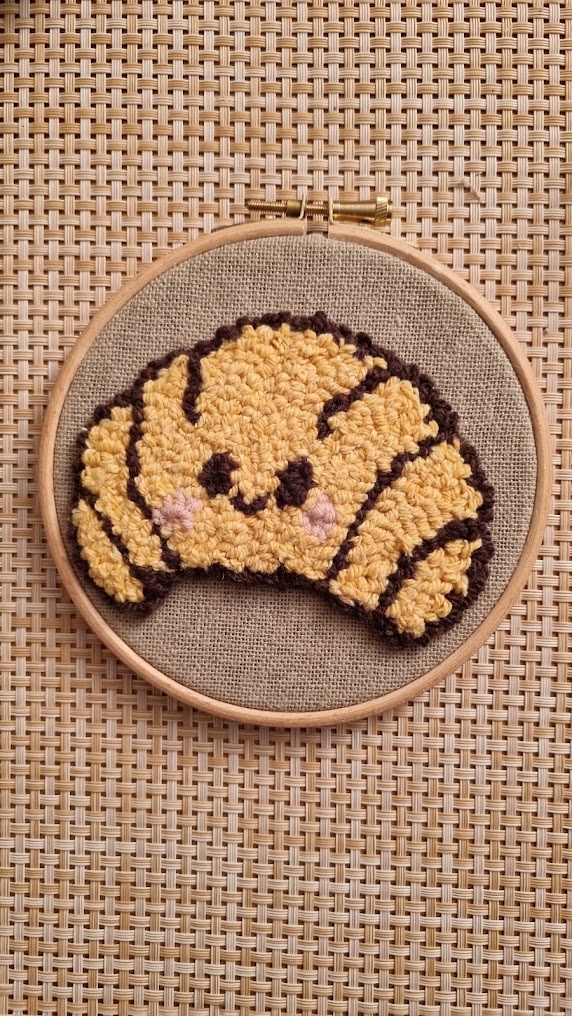 Croissant brodé au punch needle sur un tambour en bois, pièce terminée pendant l'atelier découverte