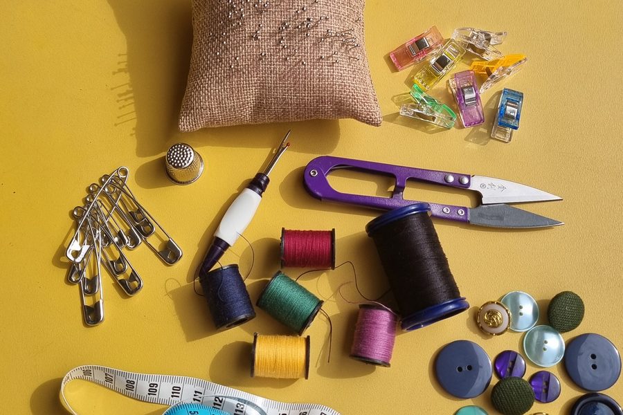 Kit de réparation textile : pelote d'épingles, dé à coudre, découvit, ciseaux, bobines de fil et boutons assortis