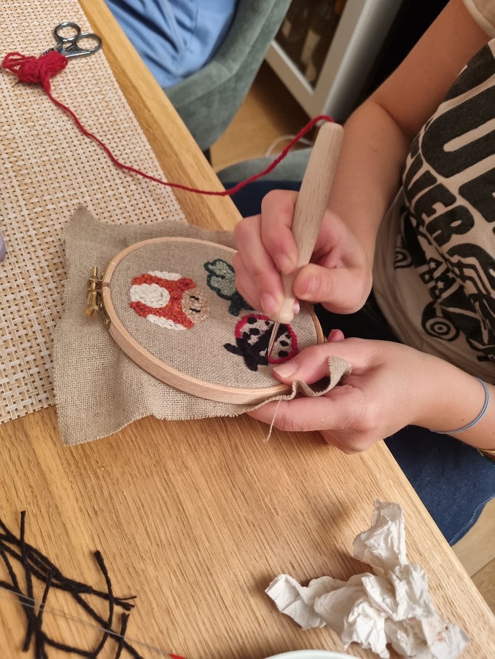 Petit personnage de jeu vidéo brodé au punch needle en laine colorée, du type de ce que réalisent les enfants pendant leur cycle de cours